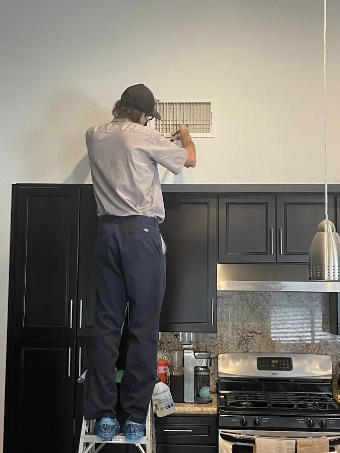 Technician inspecting an air vent during HVAC service in Ossining